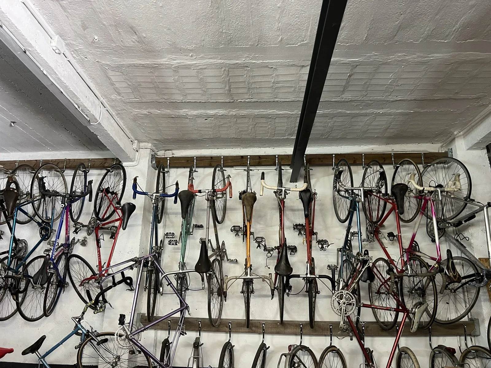 Wall of vintage racing bikes hanging in the Vélo-Cité workshop in Avignon